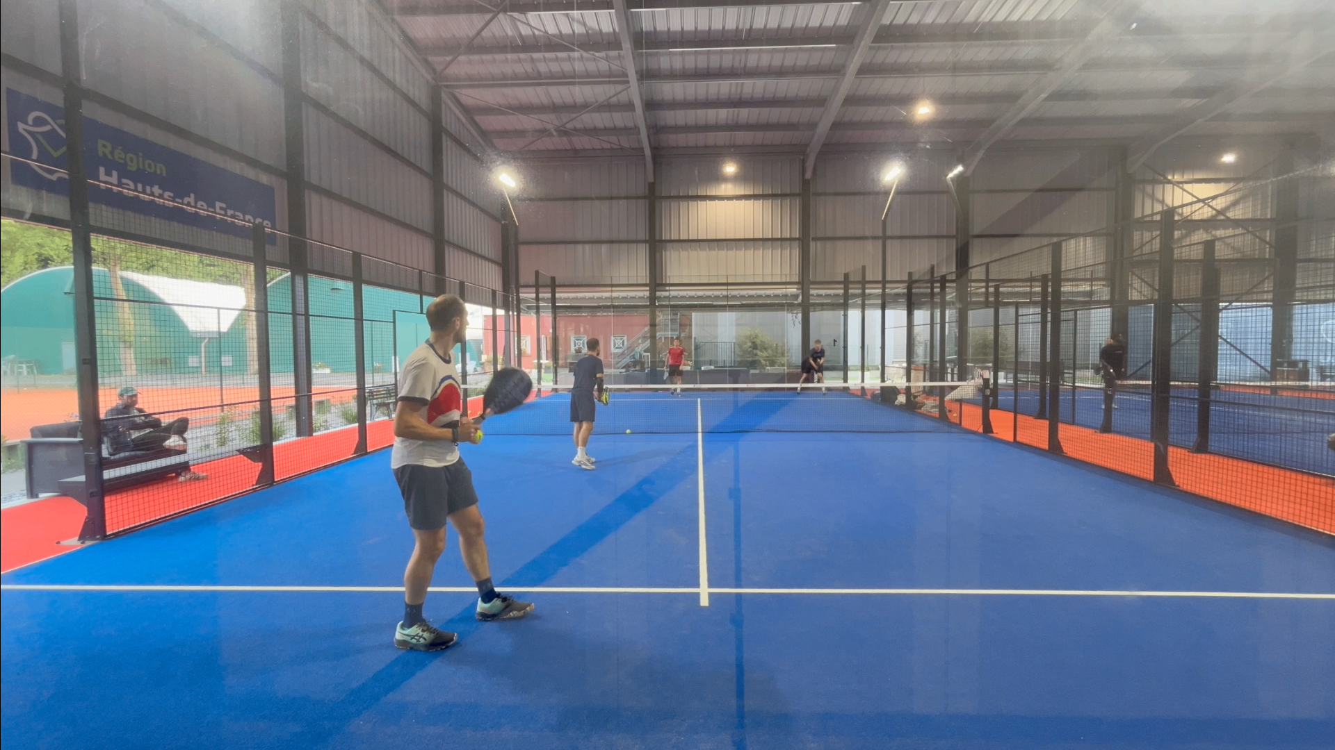 Angle de prise de vue idéal pour filmer un match de padel depuis la vitre de fond